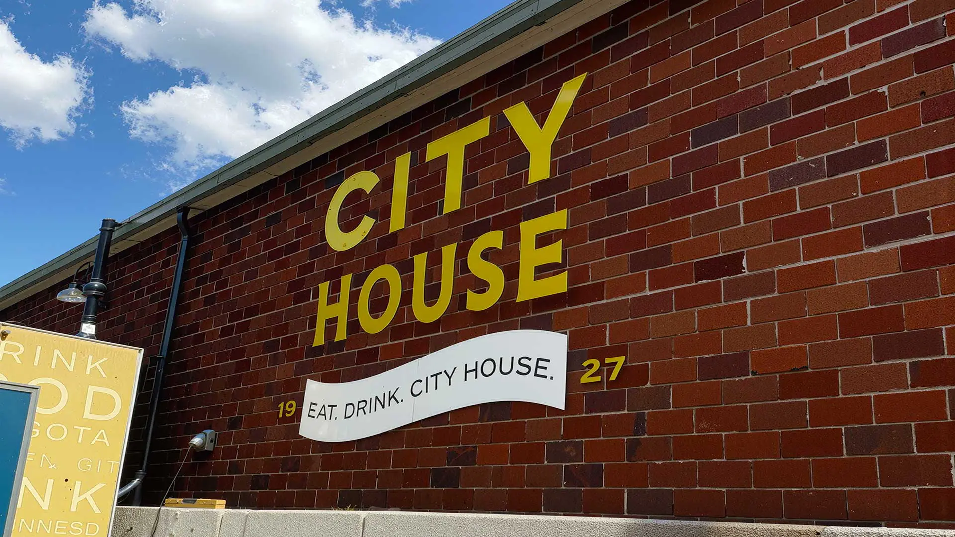 City House sign on brick facade, peek of food truck against building