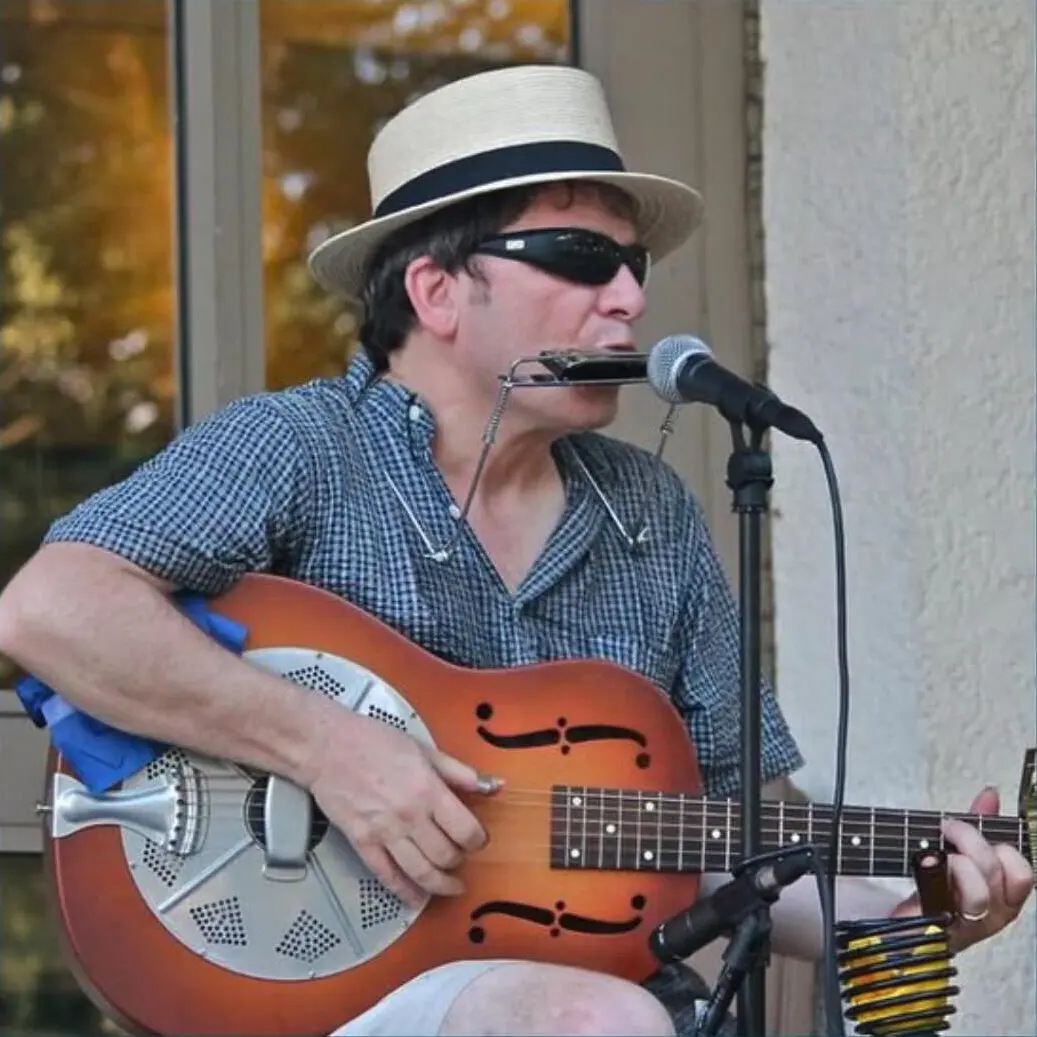 Matt Yetter playing guitar and harmonica